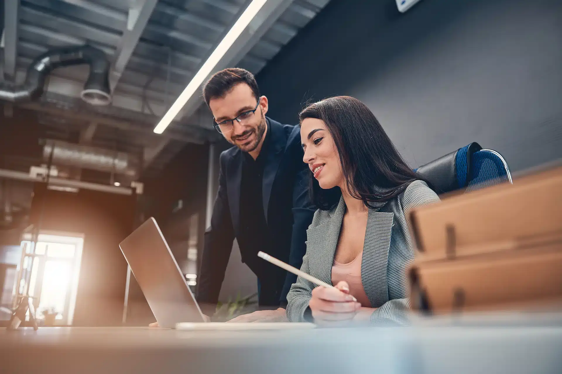 smiling-co-workers-looking-at-laptop-while-discuss-2023-11-27-05-36-28-utc.jpg